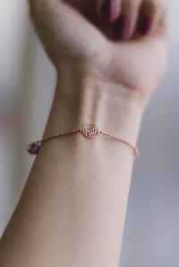 person wearing pink gold colored faith bracelet